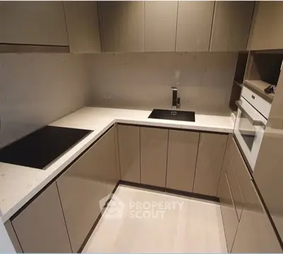 Modern kitchen with sleek cabinetry and built-in appliances in a contemporary apartment.