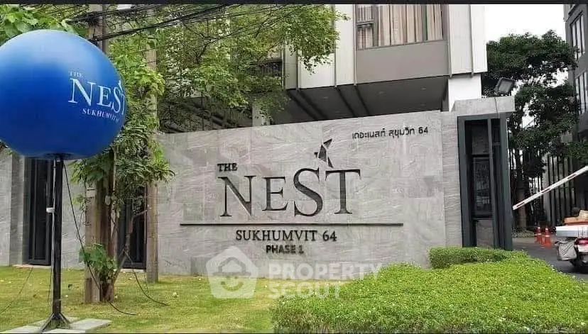 Modern entrance of The Nest Sukhumvit 64 Phase 1 with lush greenery and sleek design.