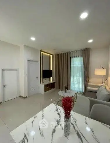 Modern living room with elegant decor and natural light, featuring a cozy sofa and stylish marble table.