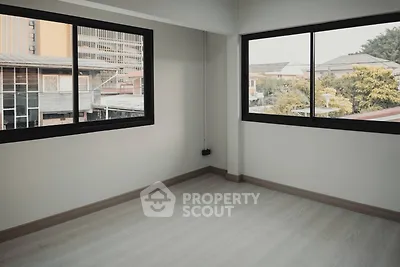 Spacious and well-lit corner unit with large windows offering an urban view, perfect for creating a personalized living space.