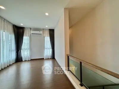 Spacious modern living room with large windows and elegant curtains