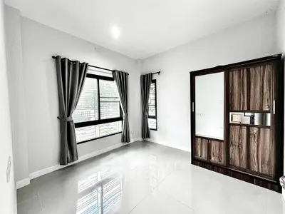 Spacious empty room with large windows and modern wardrobe, perfect for customization.