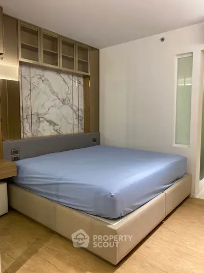 Modern bedroom with elegant marble accent wall and spacious bed
