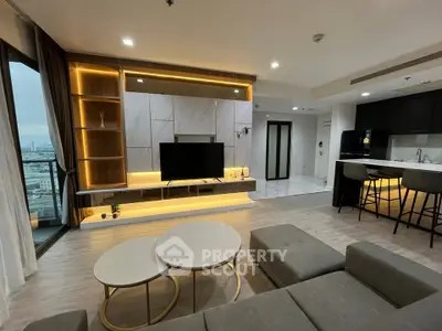 Modern living room with open kitchen and city view, featuring stylish furniture and ambient lighting.