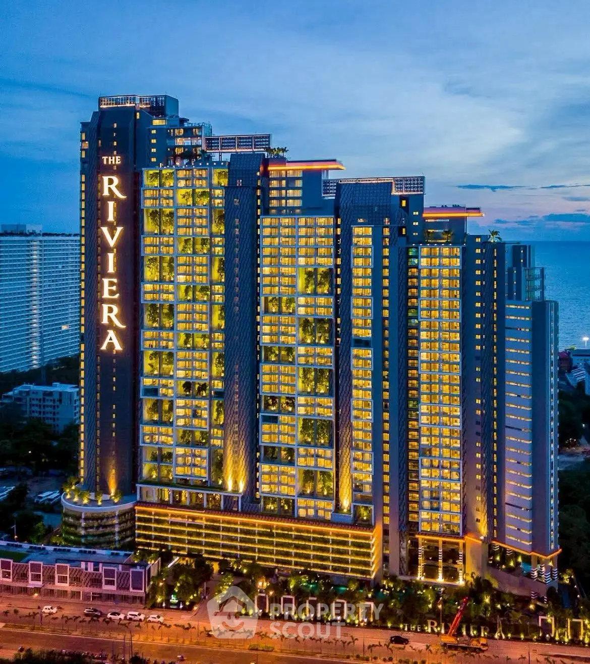 Luxurious high-rise building with stunning night illumination and ocean view.