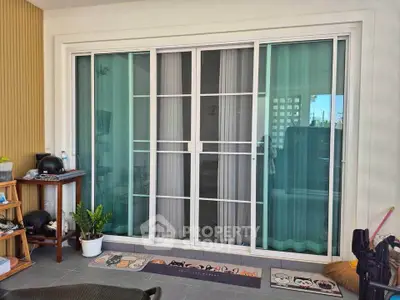 Charming balcony with sliding glass doors and cozy decor, perfect for relaxation.