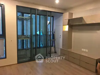 Modern living room with sliding glass doors and built-in storage solutions.
