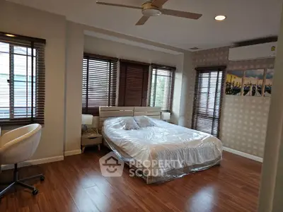 Spacious bedroom with modern decor and large windows for natural light.
