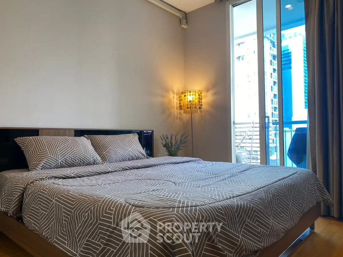 Modern bedroom with stylish decor and balcony view in urban apartment