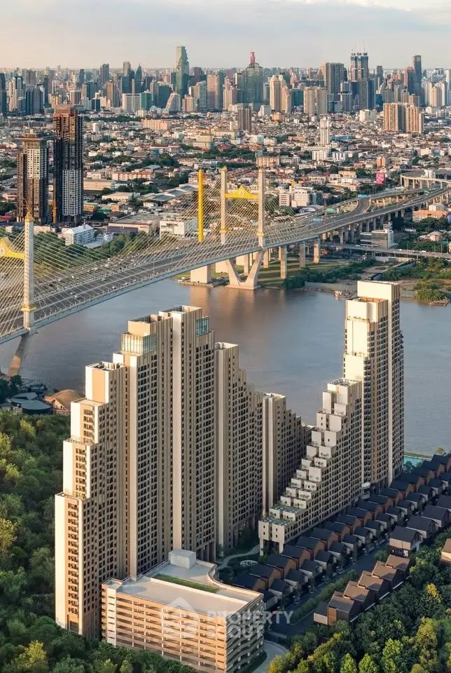 Stunning aerial view of modern high-rise buildings by a river with a cityscape backdrop, showcasing urban living.