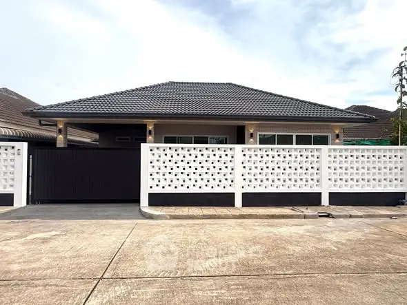 Charming single-story home with modern facade and stylish fence in a serene neighborhood.