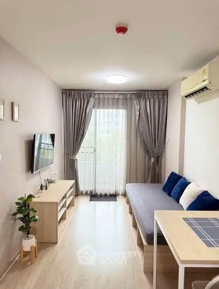 Modern living room with sleek furniture and natural light, featuring a cozy sofa and wall-mounted TV.