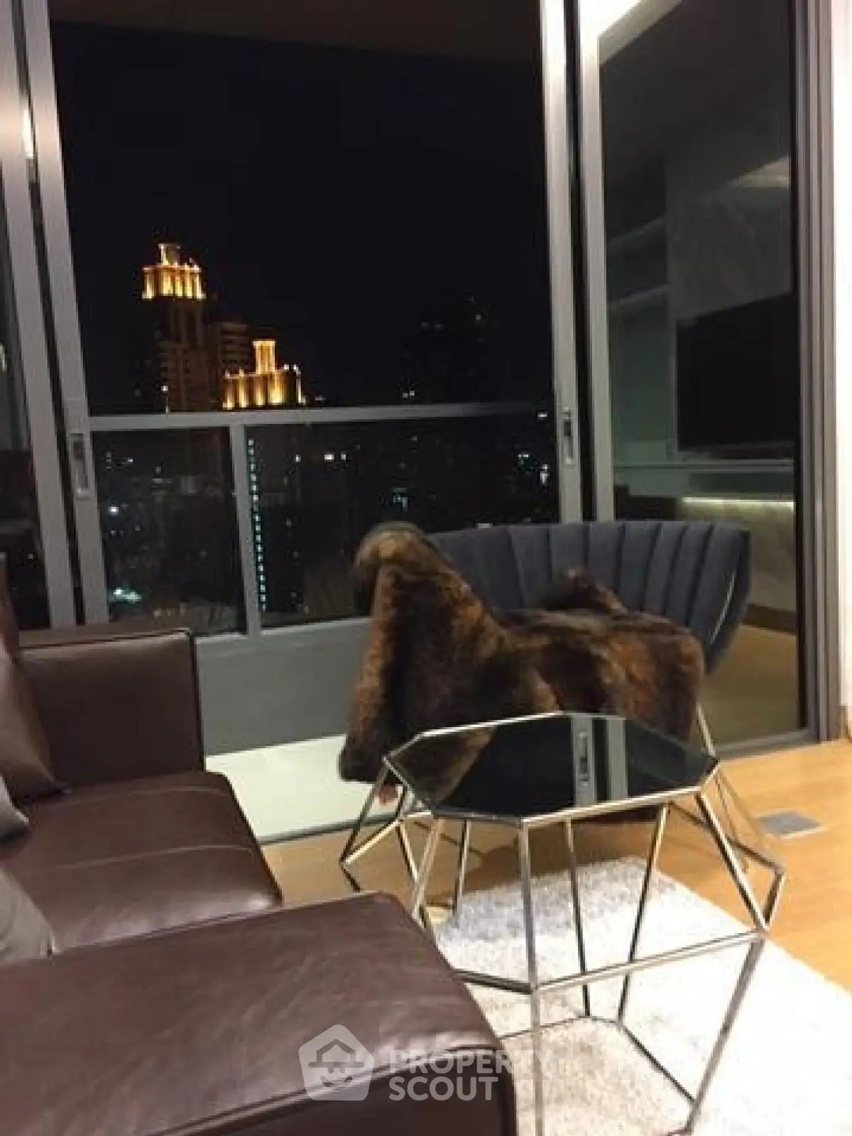 Luxurious living room with city view and modern decor at night