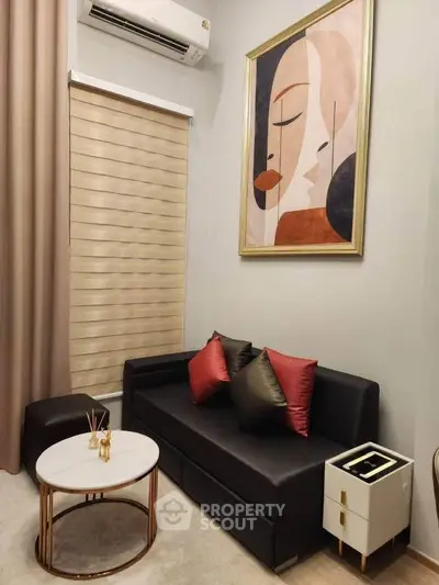 Stylish living room with modern art, sleek black sofa, and elegant decor accents.