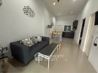 Modern living room with sleek furniture and open kitchen layout