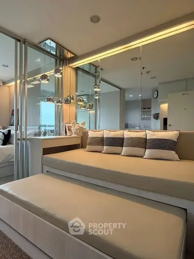 Modern living room with elegant decor and mirrored walls, featuring cozy seating and ambient lighting.