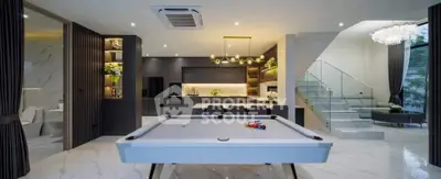 Luxurious open-plan living area with pool table and modern kitchen design