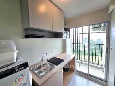 Modern kitchen with sleek cabinetry and balcony view, perfect for urban living.