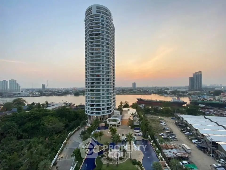 Stunning high-rise building with river view and luxurious pool area at sunset.