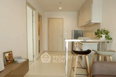 Modern open-layout kitchen with sleek design and stylish bar stools in a cozy apartment setting.