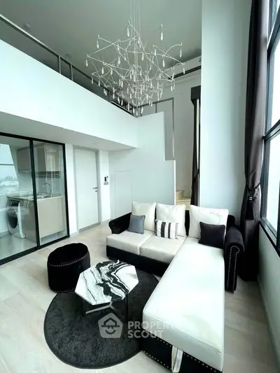 Luxurious modern living room with high ceilings and elegant chandelier in a stylish apartment.