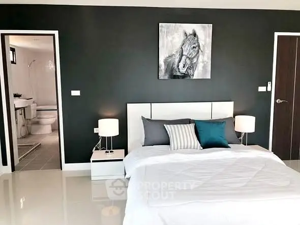 Modern bedroom with stylish decor and ensuite bathroom in luxury apartment.