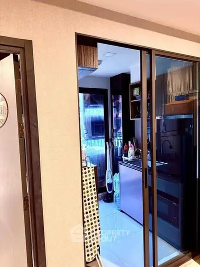 Modern kitchen with sleek design and glass sliding doors in a contemporary apartment.