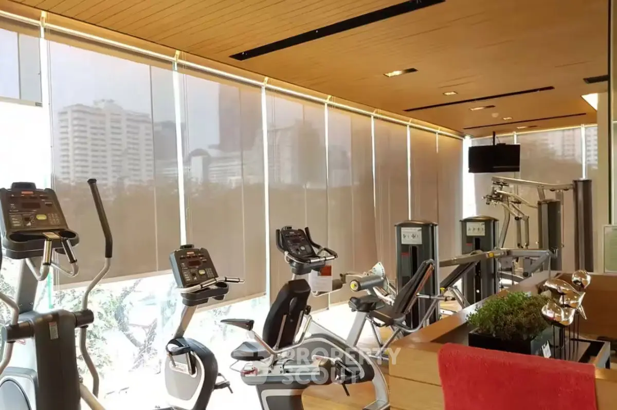 Modern gym with state-of-the-art equipment and city view in luxury real estate property.