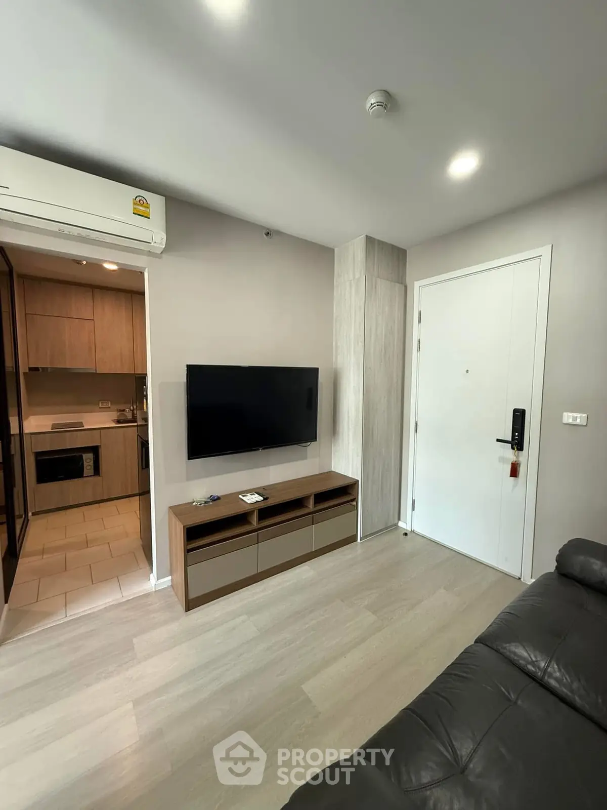 Modern living room with sleek TV setup and adjacent kitchen area