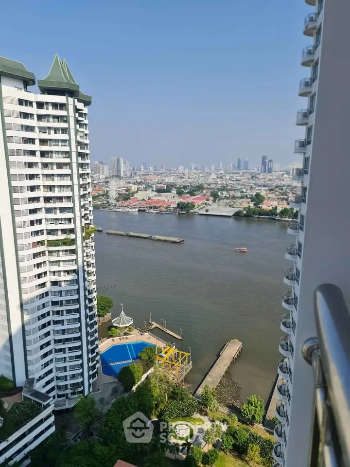 Stunning river view from high-rise balcony with pool and city skyline.