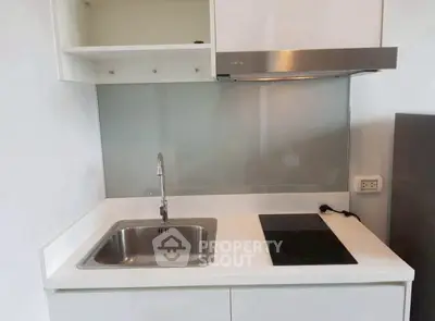 Modern compact kitchen with sleek design and electric cooktop