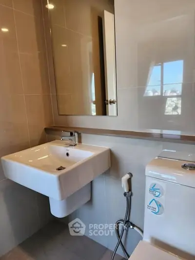 Modern bathroom with sleek sink and toilet in contemporary apartment.