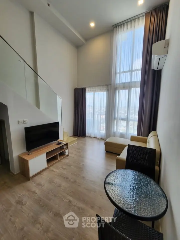 Spacious modern living room with high ceilings and large windows offering stunning views.