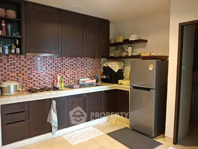 Charming kitchen with dark wood cabinets and modern appliances in cozy home