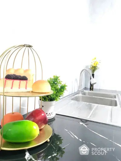 Modern kitchen with sleek black countertop and stylish fruit display