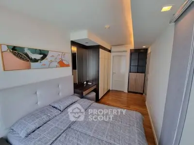 Modern bedroom with stylish decor and wooden flooring in a contemporary apartment.