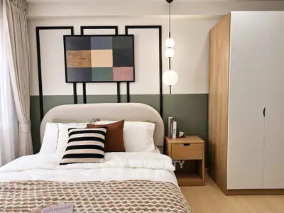 Stylish bedroom with modern decor and cozy bedding in a contemporary apartment.