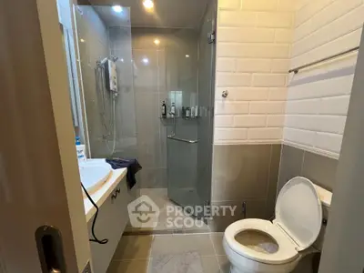 Modern bathroom with glass shower and sleek fixtures in contemporary home.