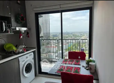 Charming kitchen with washing machine and stunning city view from balcony.