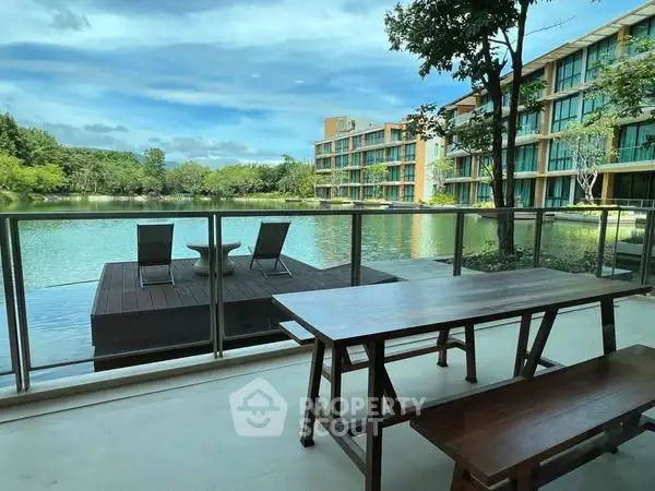 Stunning waterfront view from a modern apartment balcony with outdoor seating.