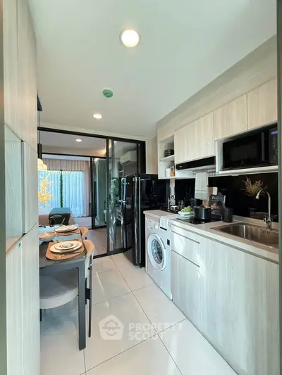 Modern kitchen with sleek cabinetry, integrated appliances, and dining area in a stylish apartment.