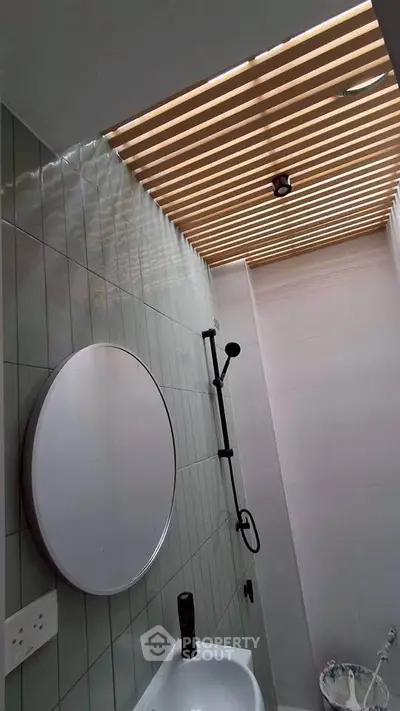 Modern bathroom with stylish ceiling design and round mirror