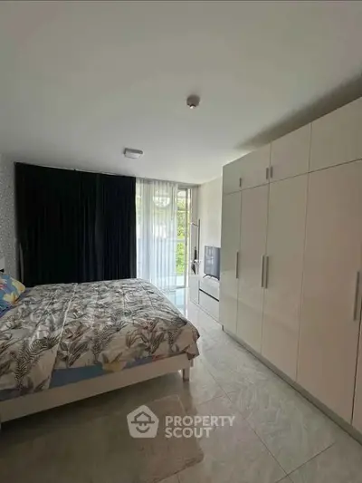 Spacious bedroom with modern wardrobe and large window view