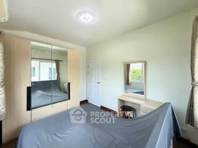Bright bedroom with mirrored wardrobe and cozy dressing table, perfect for relaxation and comfort.