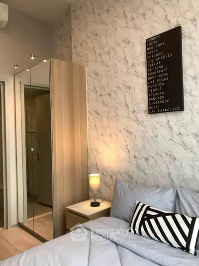 Modern bedroom with stylish decor and mirrored wardrobe in a chic apartment.