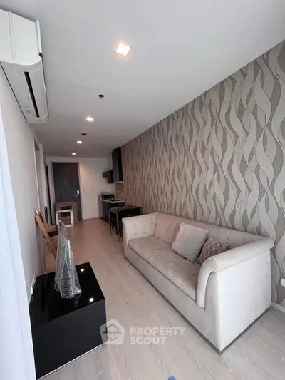 Modern living room with stylish wallpaper and comfortable sofa in a contemporary apartment.