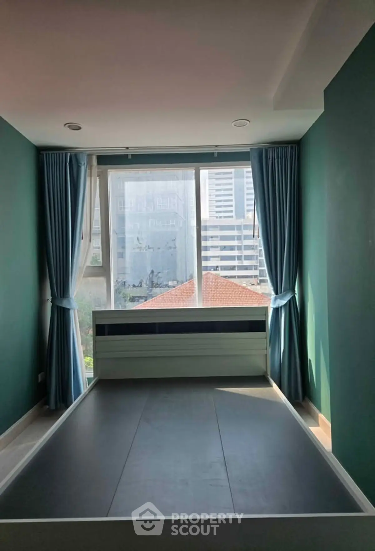 Spacious bedroom with large window offering city views, featuring elegant curtains and modern design.