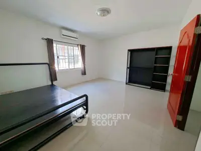 Spacious bedroom with minimalist design and ample natural light.