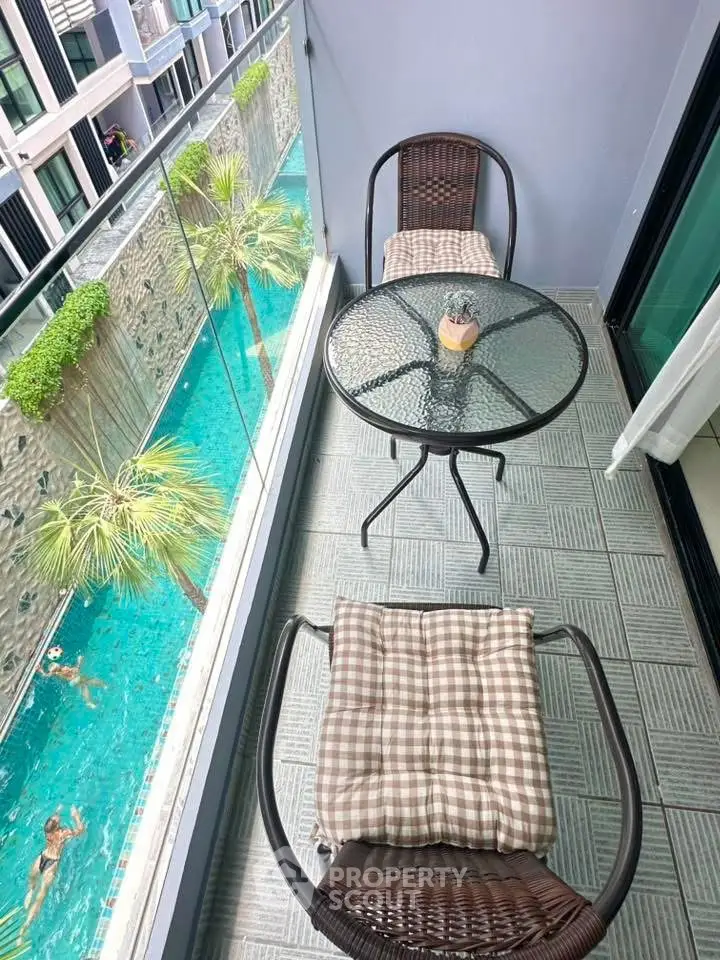 Chic balcony overlooking pool with stylish seating and glass railing