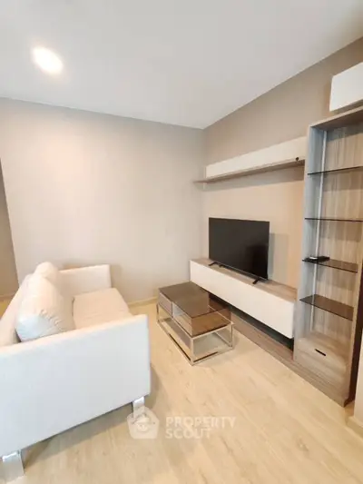 Modern living room with sleek furniture and mounted TV, perfect for relaxation.